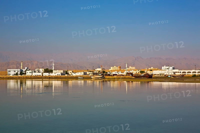 Trcoken-laid dhows against a city backdrop