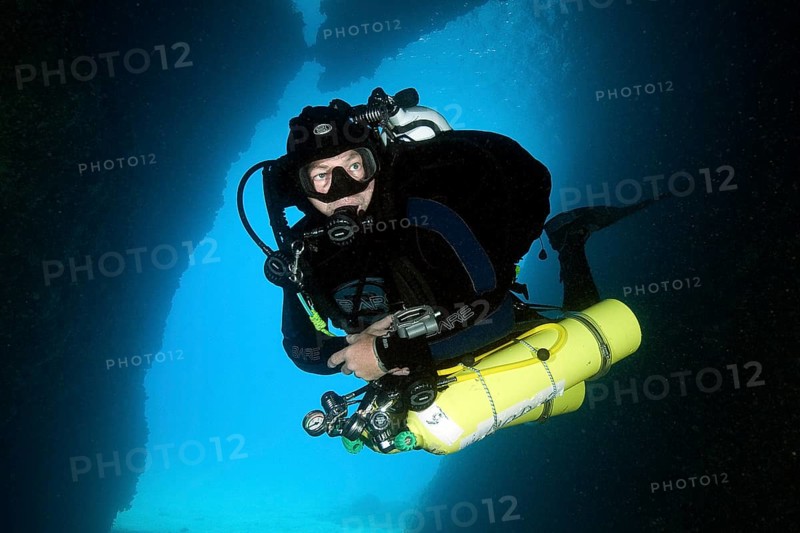 Diver does cave dive wearing special equipment with stage tanks