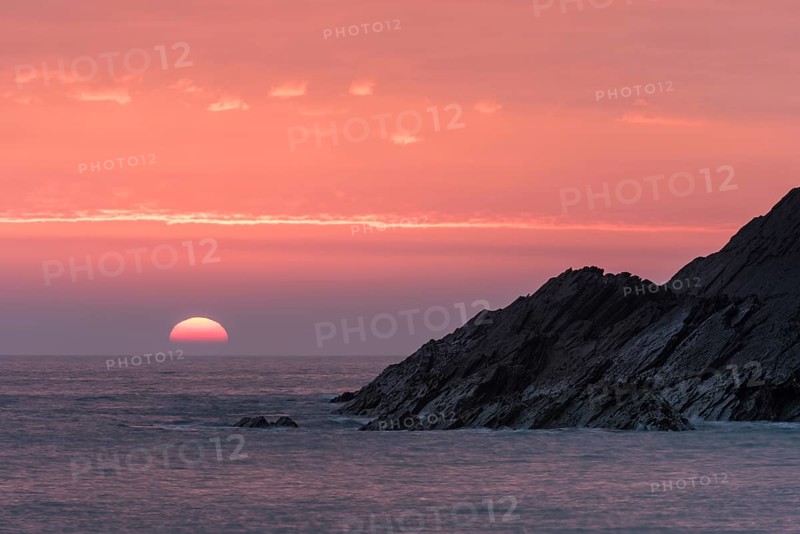 Cliff and ocean at sunset
