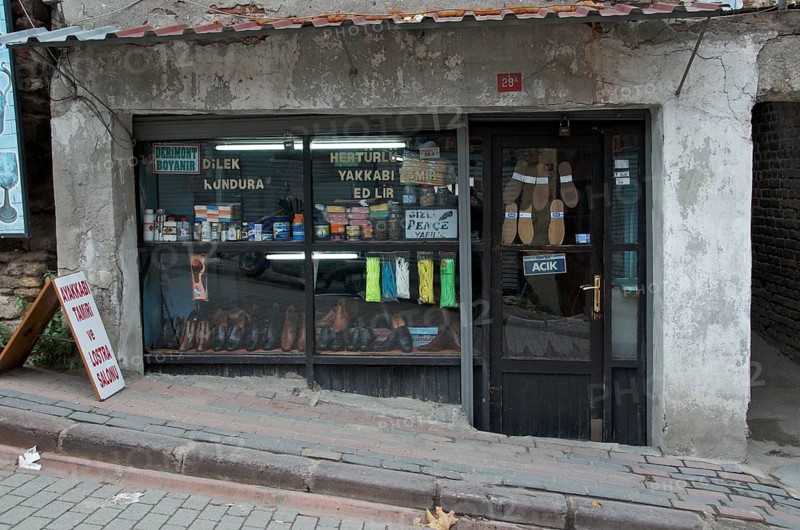 Old cobbler's shop with shop window on street with slope