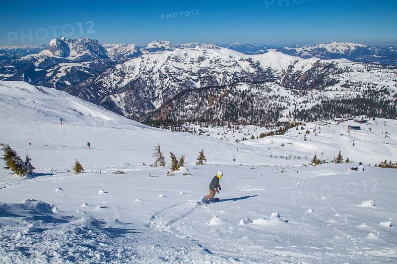 Snowboarders in the terrain next to piste 5