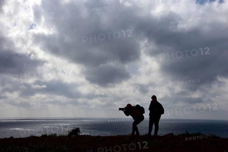 Women photographers with camera at the cloudy sea