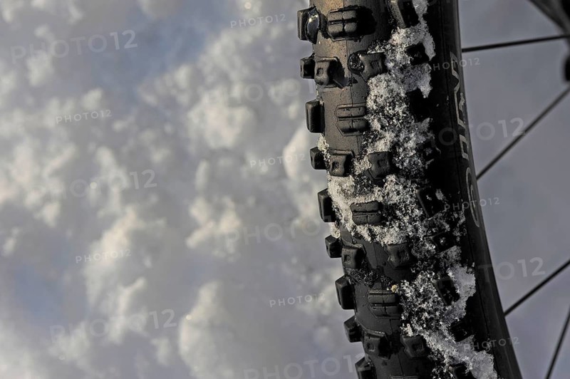 Close-up of bicycle tyre with tread in snow