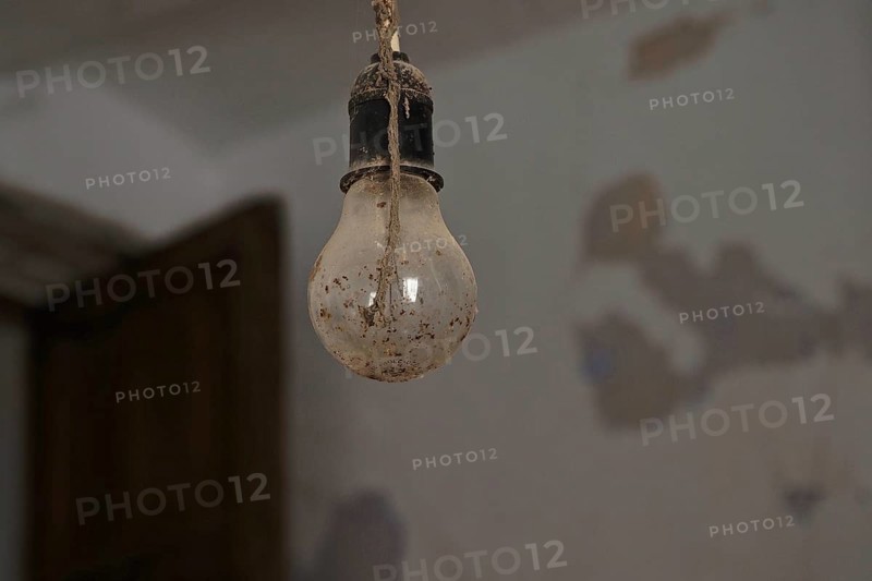 Dirty light bulb in socket hanging from the ceiling