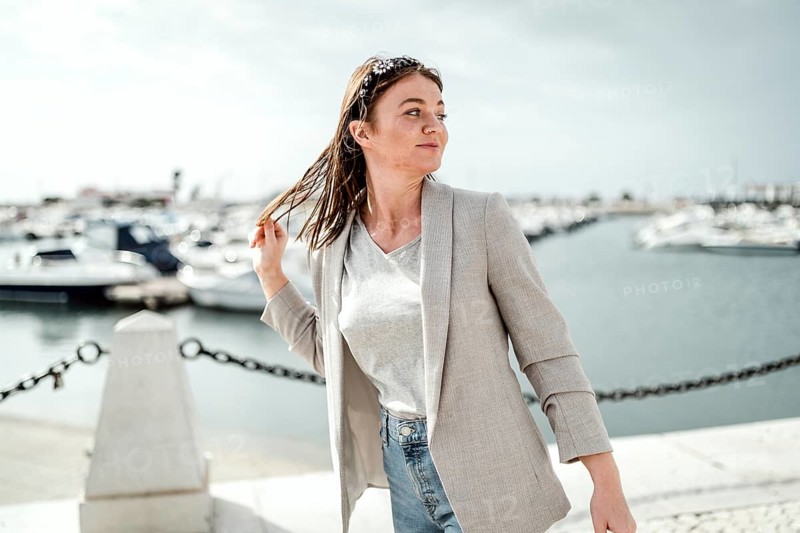Portrait of young woman walking by marina in Faro