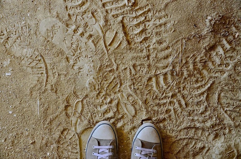 Sports shoes on dusty clay floor with footprints
