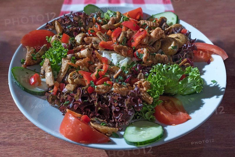 Salad with roasted turkey strips and fresh mushrooms served in a garden restaurant
