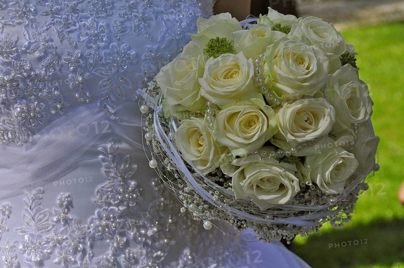 Wedding dress and bridal bouquet of yellow roses and pearl necklace