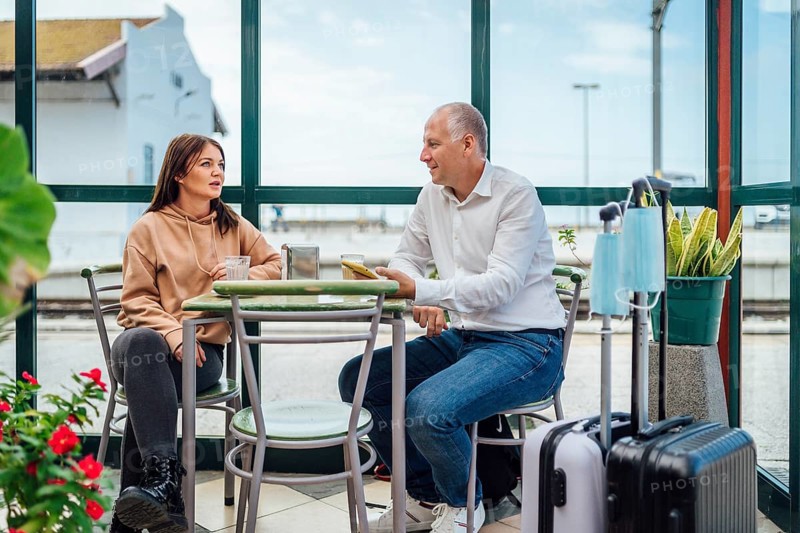 A couple of travelers drinking coffee and checking something on the phone