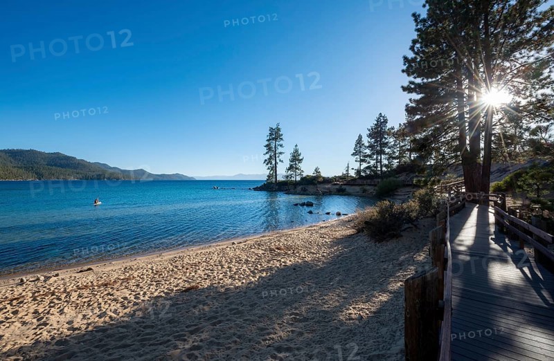 Wooden walkway on sandy beach with sun star