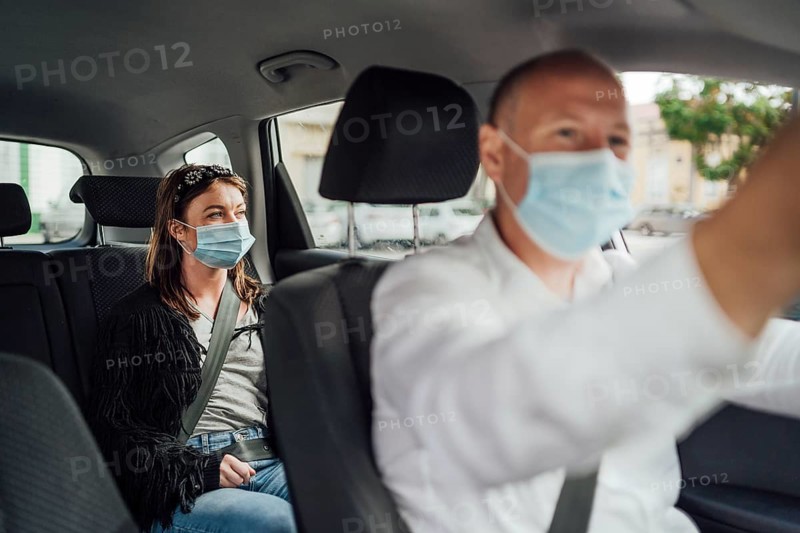 Taxi driver in a mask with a female client