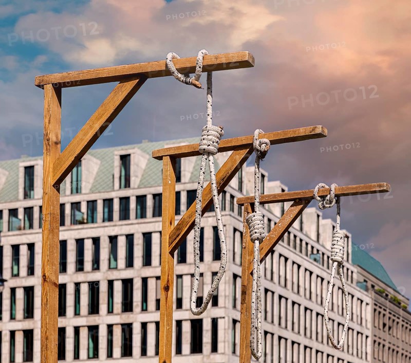 Symbolic gallows stand in front of the Brandenburg Gate during a protest rally