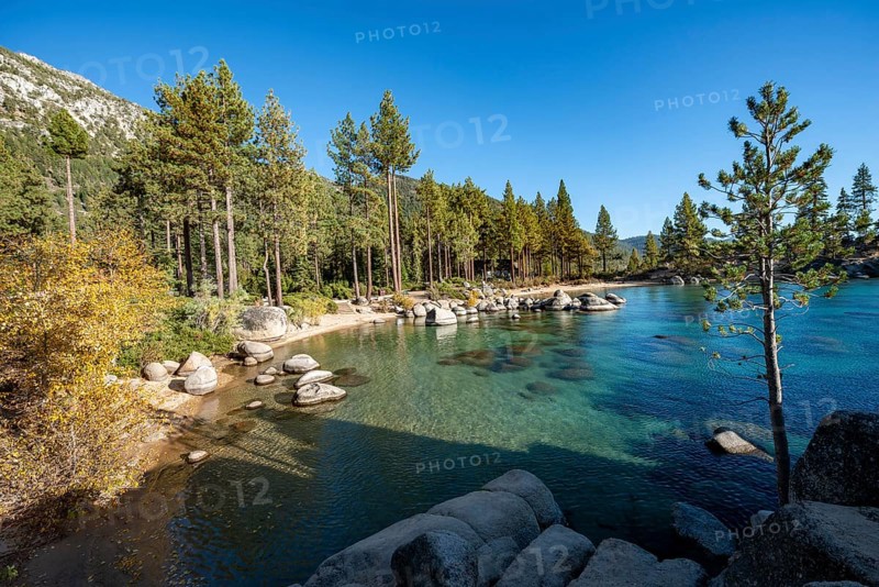 Sand beach and round stones in the water