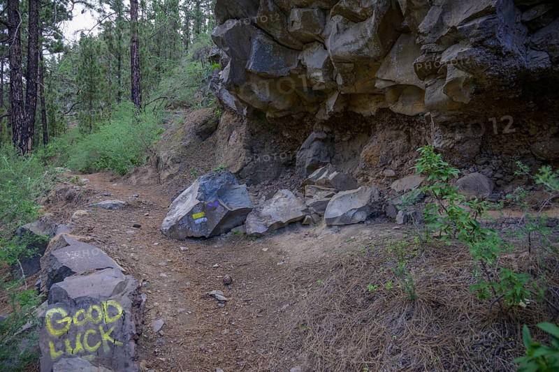 Rockfall hazard and ironic inscription on rocks good luck