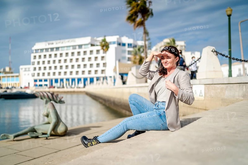 Young woman sitting by the marina in Faro