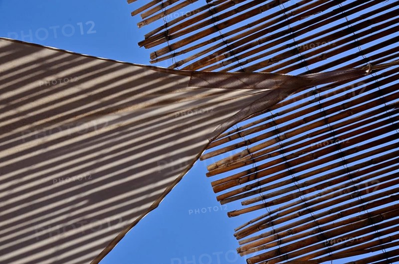 Sun sail meets sun straw mat in the blue sky