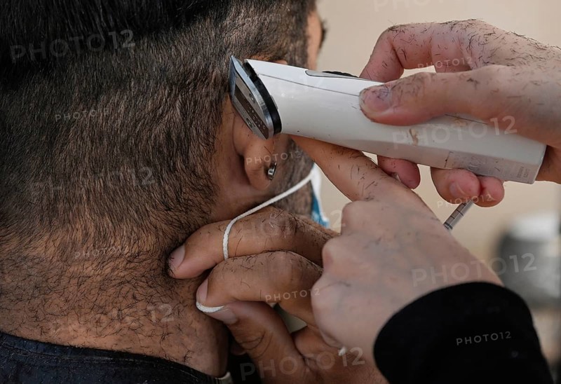 Hair clippers around the ear with mouth guard