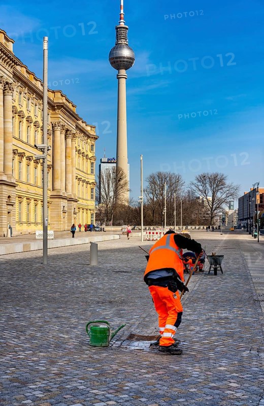Street sweeper cleans the pavement in front of the portal at Neues Schloss