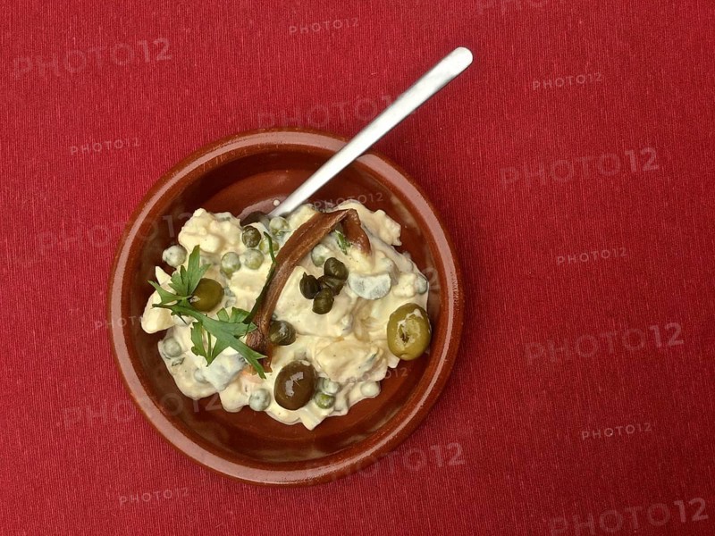 Terracotta dish Russian salad with anchovies