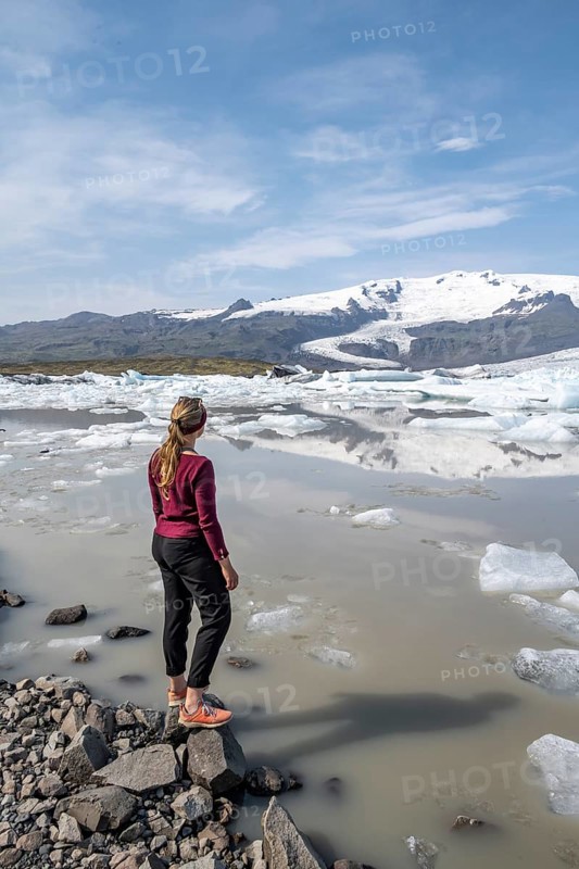 Woman standing in front of Fjallsarlon ice lagoon