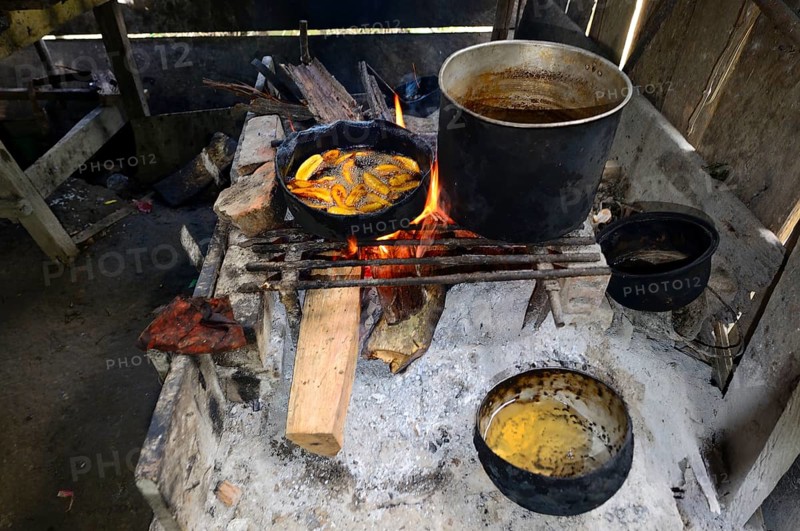Fried bananas in a pan over a wood fire in a hut
