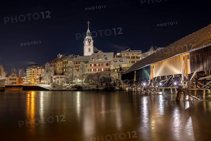 Old town and wooden bridge over the Aare in snow
