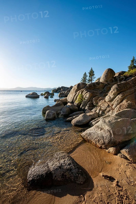 Sand beach and round stones in the water