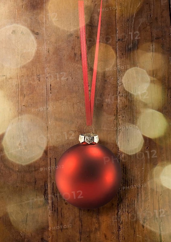 A red Christmas ball on a red ribbon