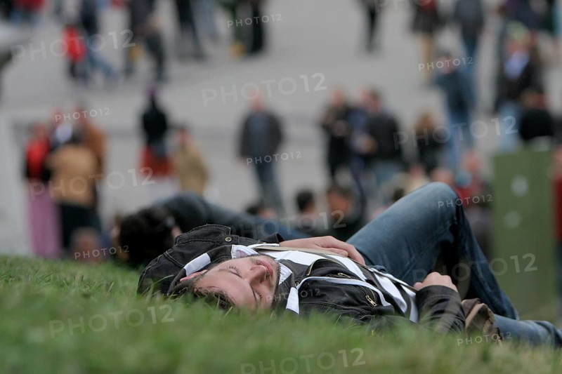 Young man sleeps off beer binge in a meadow