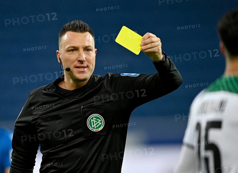Referee Sven Jablonski shows yellow card to Ramy Bensebaini Borussia Moenchengladbach BMG