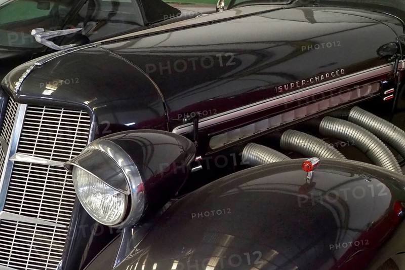Lamp and radiator grille of a black Auburn Speedster from the side