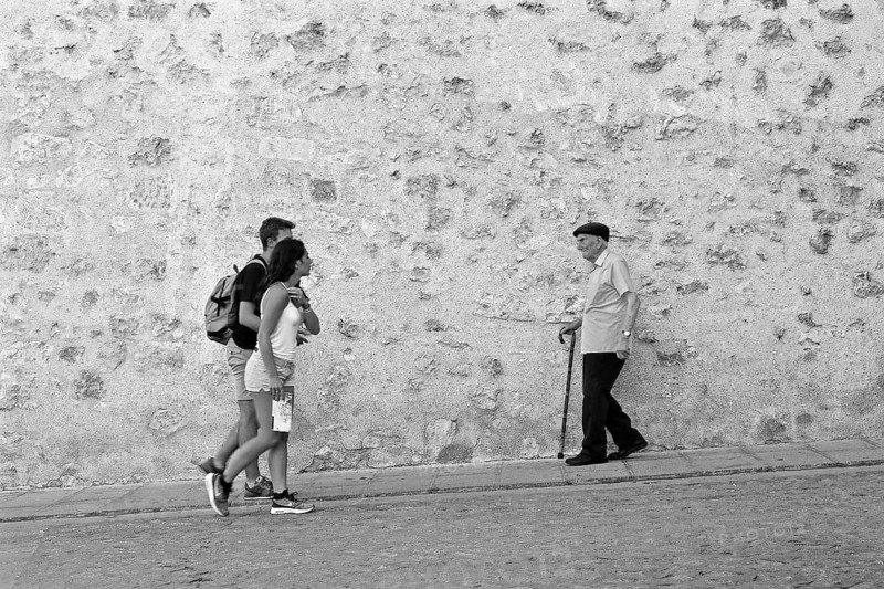 Young couple meets old man with cane