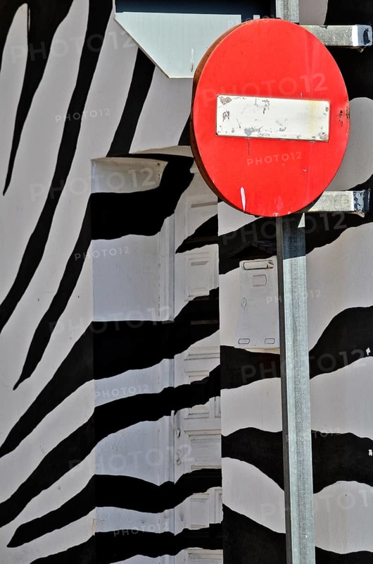 Sign with No trespassing in front of wall with zebra pattern