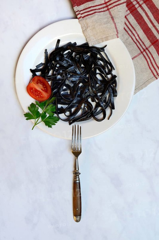 Black pasta with squid ink on plate