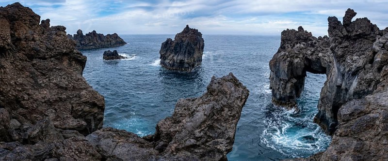 Rocky lava coast with rock gate