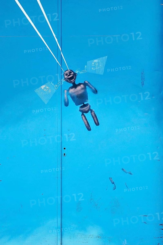 Figure as parachutist at blue metal door