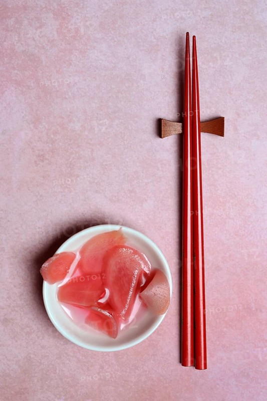 Pickled ginger slices in bowl and chopsticks