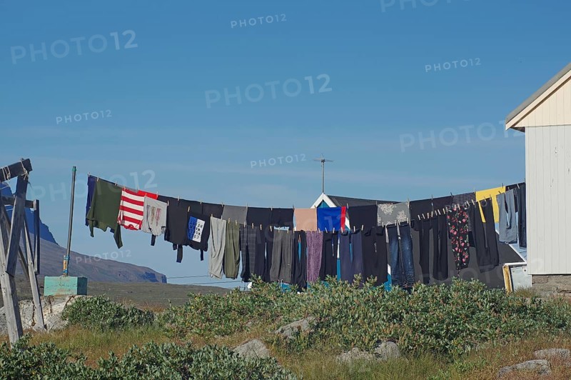 Laundry hanging to dry in front of simple wooden houses