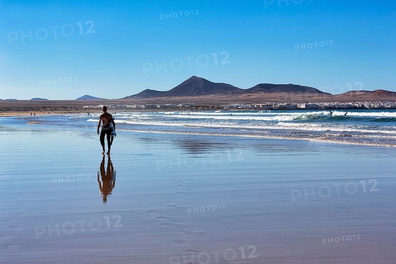Stroller with surfboard on the beach
