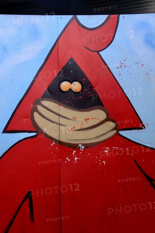 Red figure with hood and mouth guard sprayed on metal door