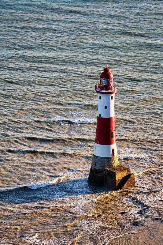 Red and white lighthouse in the sea