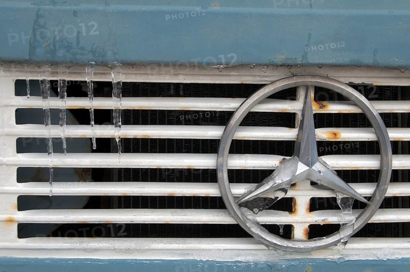Mercedes star on radiator grille of truck with icicles