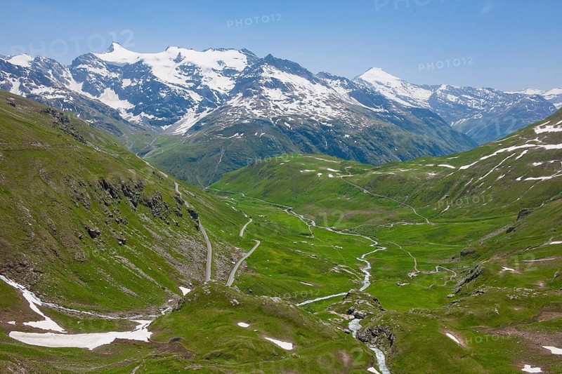 View of alpine panorama above Baumgremnze with mountain meadows below pass road Col de l'Iseran