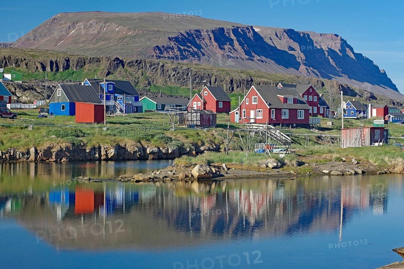 Wooden houses reflected in a calm body of water
