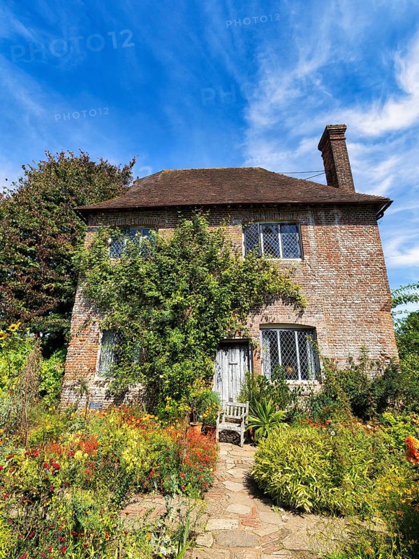 Red brick cottage with flowering front garden