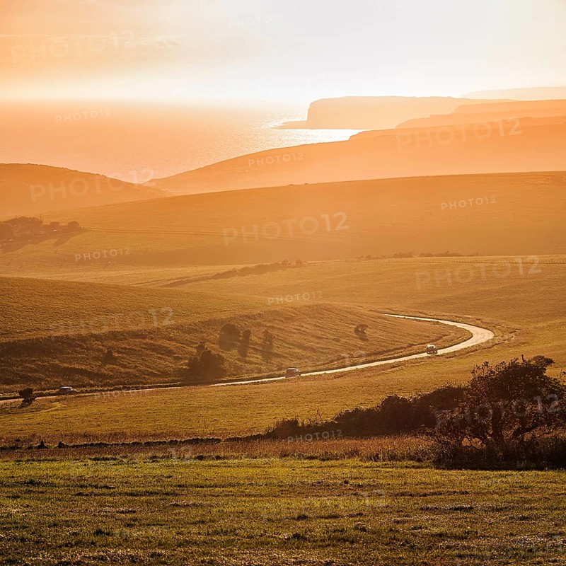 Winding country road overlooking the coast at sunset