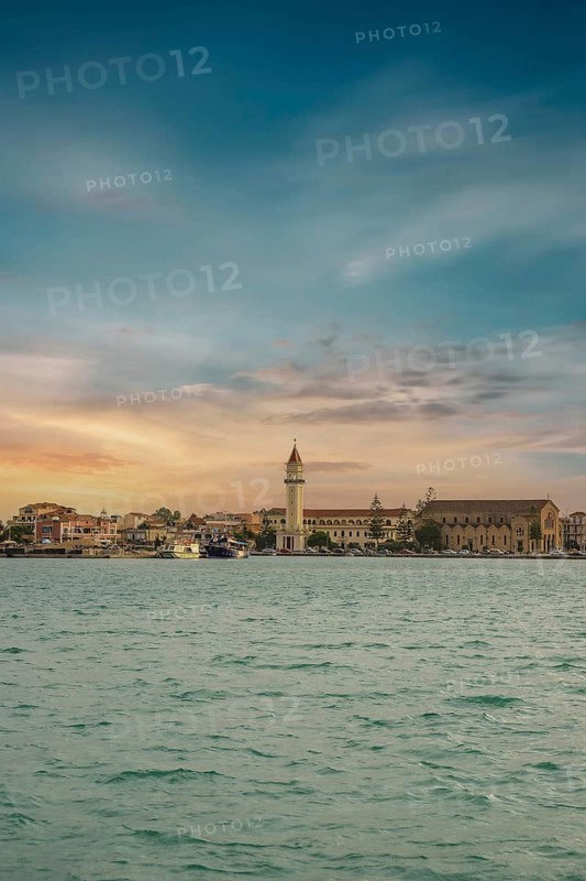 Sunset view over the sea to a Mediterranean town. St. Dionisius Church