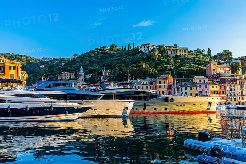 Luxury yachts anchor in the harbour of Portofino in the morning sun