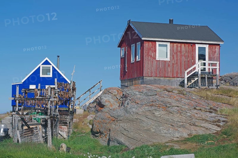 Racks of dried fish in front of simple wooden houses