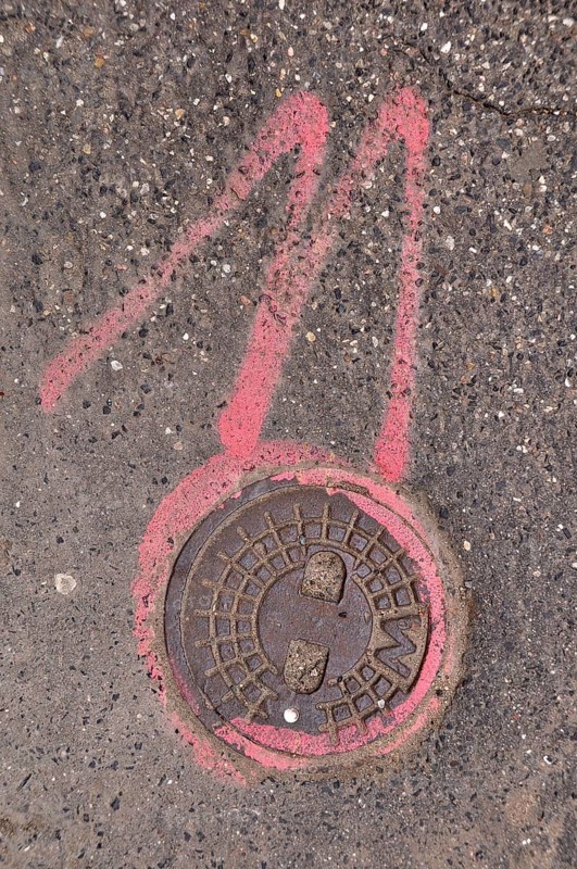 Manhole cover lid and number 11 in pink